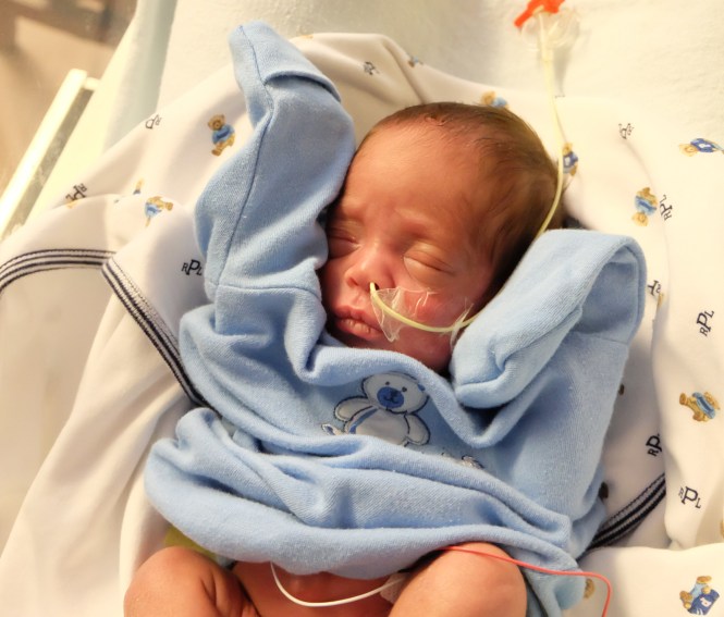 Max not quite fitting in to his smallest onesie